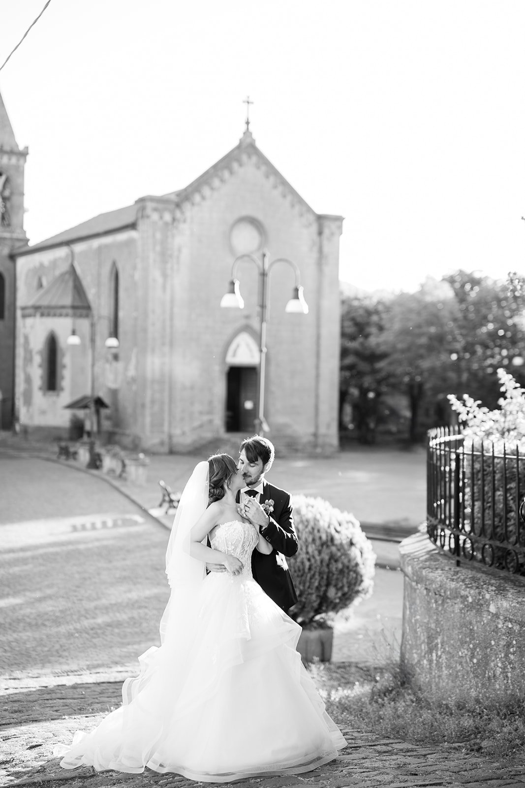 A couple walking through Tuscan arches